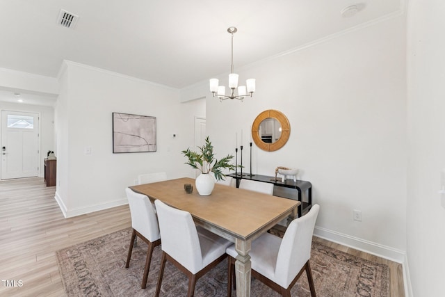 1625 Plover Cir, Fuquay Varina, NC 27526 - dining space featuring light wood-style floors, a chandelier, and crown molding