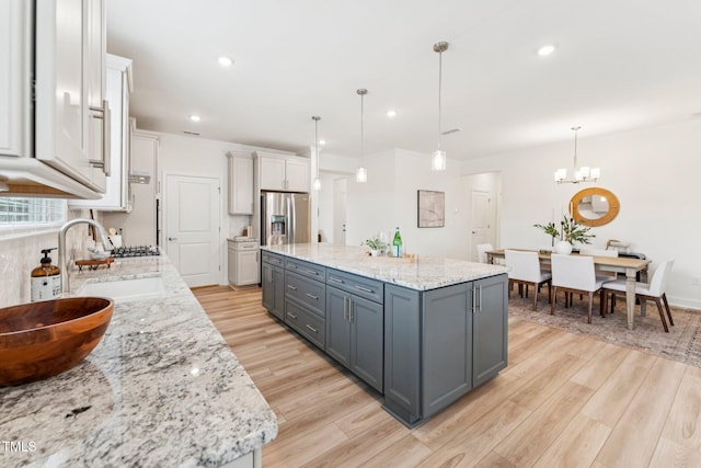 1625 Plover Cir, Fuquay Varina, NC 27526 - kitchen featuring gray cabinetry, light wood-type flooring, a center island, light stone countertops, and recessed lighting