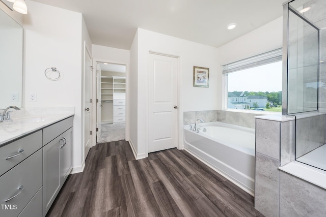 171 Piney Field Rd, Fuquay Varina, NC 27526 - bathroom featuring wood finished floors, vanity, a walk in closet, a garden tub, and recessed lighting