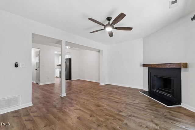 129 Assembly Ct, Cary, NC 27511 - unfurnished living room featuring ceiling fan, wood finished floors, baseboards, and a fireplace with raised hearth