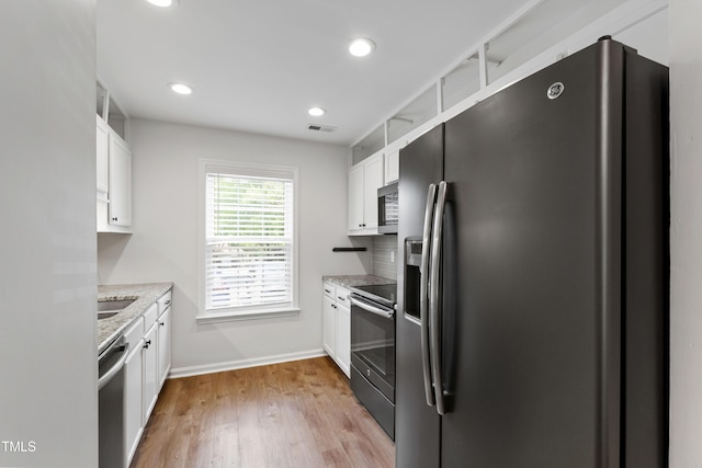 129 Assembly Ct, Cary, NC 27511 - kitchen featuring stainless steel appliances, white cabinetry, light wood finished floors, baseboards, and light stone counters