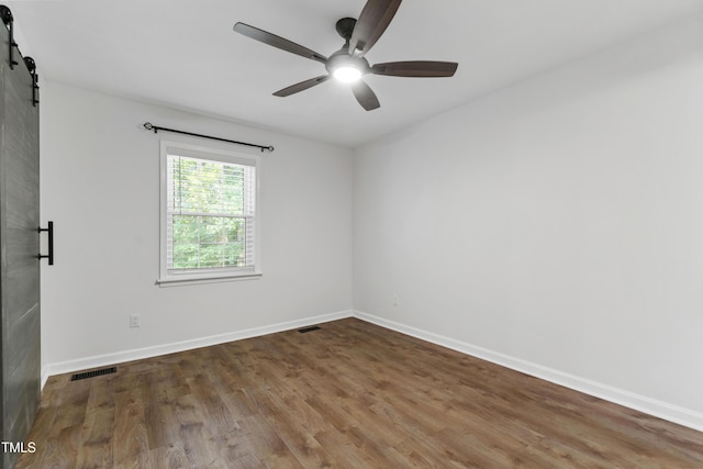 129 Assembly Ct, Cary, NC 27511 - unfurnished room with a barn door, ceiling fan, wood finished floors, and baseboards