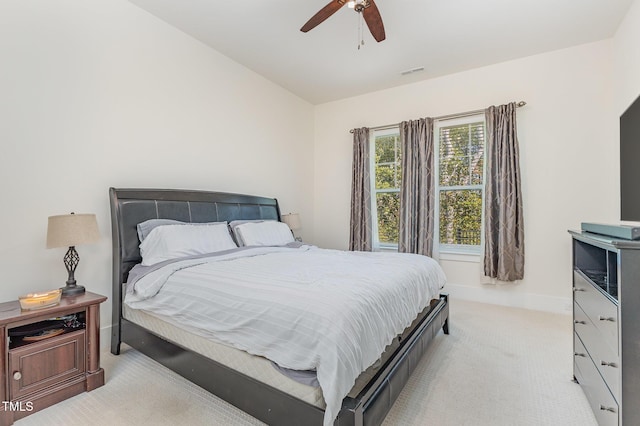 bedroom with light colored carpet, ceiling fan, and baseboards