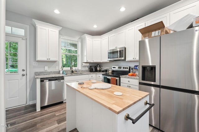 2620 Holloway St, Durham, NC 27703 - kitchen with appliances with stainless steel finishes, wood finished floors, butcher block countertops, plenty of natural light, and recessed lighting