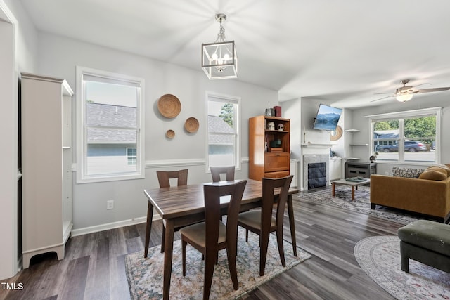 2620 Holloway St, Durham, NC 27703 - dining room with healthy amount of natural light, a chandelier, a tiled fireplace, and dark wood-type flooring