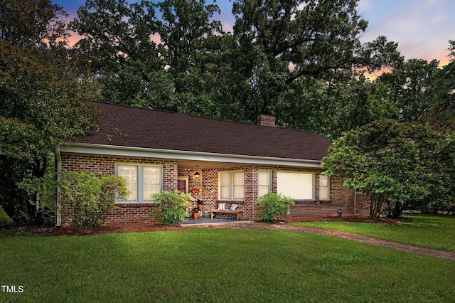 1605 Longview Ave, Tarboro, NC 27886 - view of front of home featuring brick siding, a lawn, a patio, and a chimney