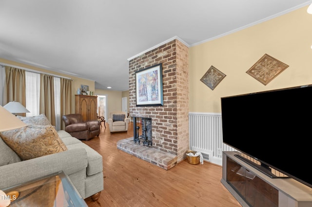 1605 Longview Ave, Tarboro, NC 27886 - living area featuring wood finished floors, a fireplace, ornamental molding, and a wainscoted wall