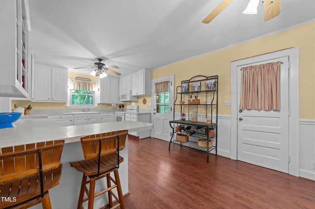1605 Longview Ave, Tarboro, NC 27886 - kitchen with ceiling fan, white appliances, a peninsula, white cabinets, and a breakfast bar area