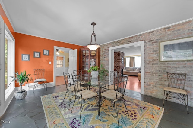1605 Longview Ave, Tarboro, NC 27886 - dining room with crown molding, a ceiling fan, brick wall, and baseboards