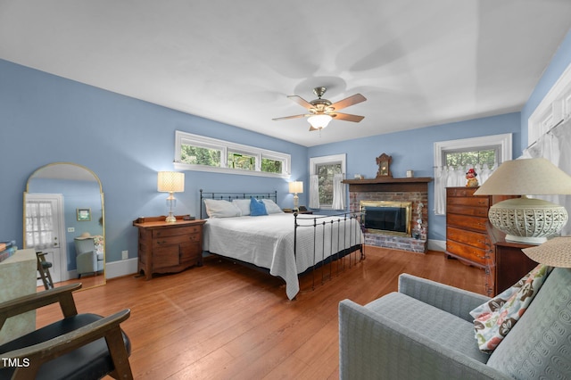 1605 Longview Ave, Tarboro, NC 27886 - bedroom featuring a brick fireplace, wood finished floors, baseboards, and ceiling fan