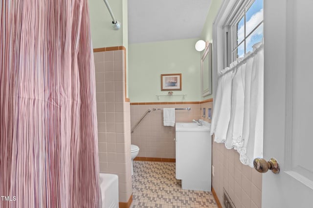 1605 Longview Ave, Tarboro, NC 27886 - full bath with tile walls, vanity, toilet, wainscoting, and shower / bathtub combination with curtain