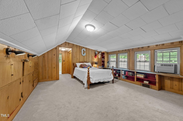 1605 Longview Ave, Tarboro, NC 27886 - bedroom with cooling unit, multiple windows, carpet, vaulted ceiling, and wood walls