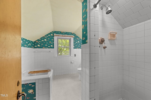 1605 Longview Ave, Tarboro, NC 27886 - bathroom with tiled shower, lofted ceiling, tile walls, toilet, and a wainscoted wall
