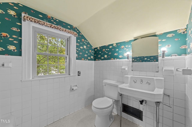 1605 Longview Ave, Tarboro, NC 27886 - half bathroom with wallpapered walls, lofted ceiling, tile walls, a wainscoted wall, and toilet