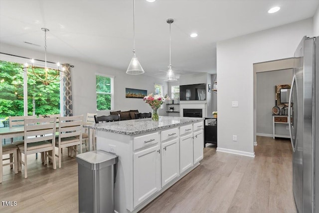 320 Everly Mist Way, Wake Forest, NC 27587 - kitchen with freestanding refrigerator, a center island, light wood-style flooring, light stone countertops, and recessed lighting