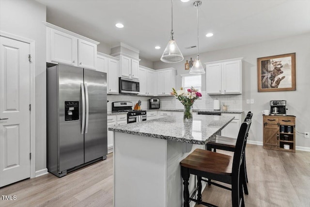 320 Everly Mist Way, Wake Forest, NC 27587 - kitchen with appliances with stainless steel finishes, white cabinetry, light wood finished floors, a kitchen island, and recessed lighting