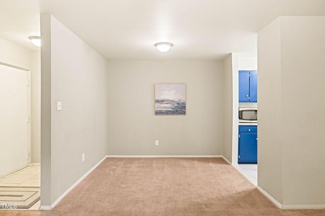 spare room with light colored carpet and baseboards