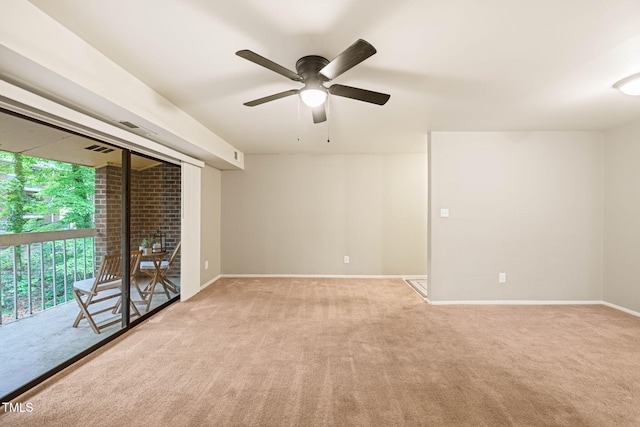 carpeted empty room featuring a ceiling fan and baseboards