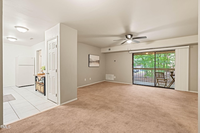 unfurnished room featuring a ceiling fan, light carpet, and baseboards