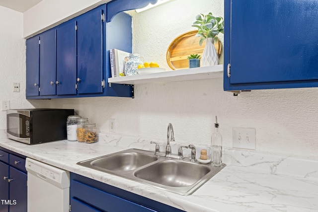 kitchen featuring dishwasher, a sink, blue cabinetry, light countertops, and a textured wall
