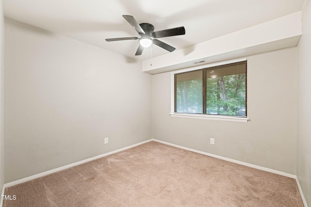 spare room featuring carpet, baseboards, and a ceiling fan