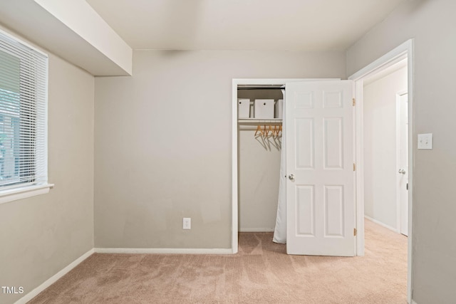 unfurnished bedroom featuring carpet, a closet, and baseboards