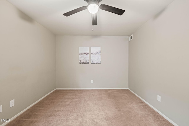 carpeted spare room with ceiling fan and baseboards
