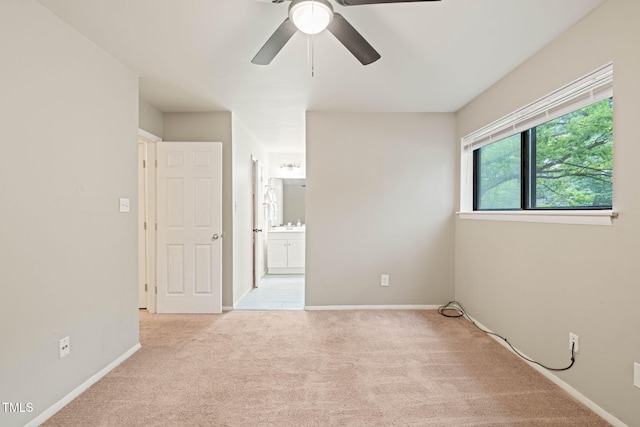 unfurnished room with carpet floors, a ceiling fan, and baseboards