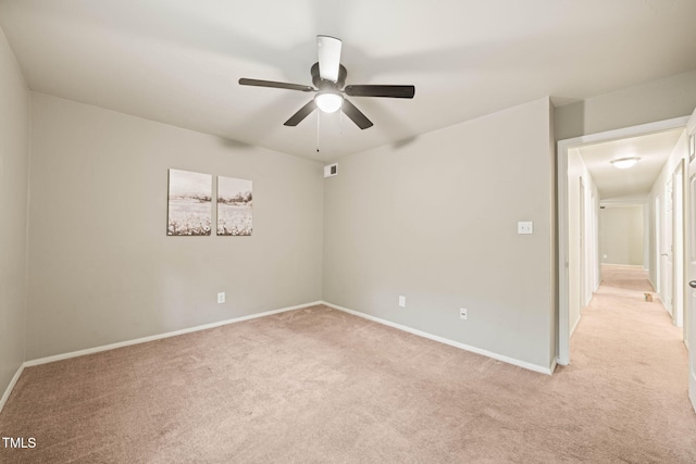 empty room featuring light carpet, ceiling fan, and baseboards