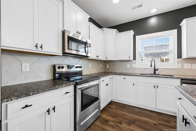 1307 Water Leaf Dr, Fayetteville, NC 28314 - kitchen with appliances with stainless steel finishes, a sink, white cabinetry, dark stone countertops, and recessed lighting