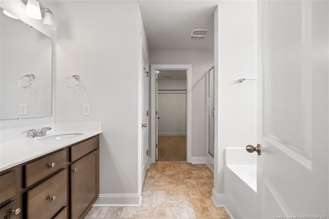 1307 Water Leaf Dr, Fayetteville, NC 28314 - full bathroom featuring vanity, baseboards, a bath, a closet, and a shower with shower door