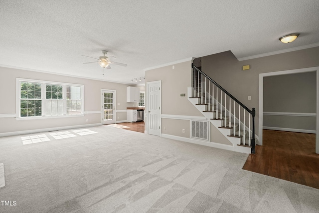 1005 Barmkin Pl, Knightdale, NC 27545 - unfurnished living room with ceiling fan, a textured ceiling, ornamental molding, stairway, and carpet