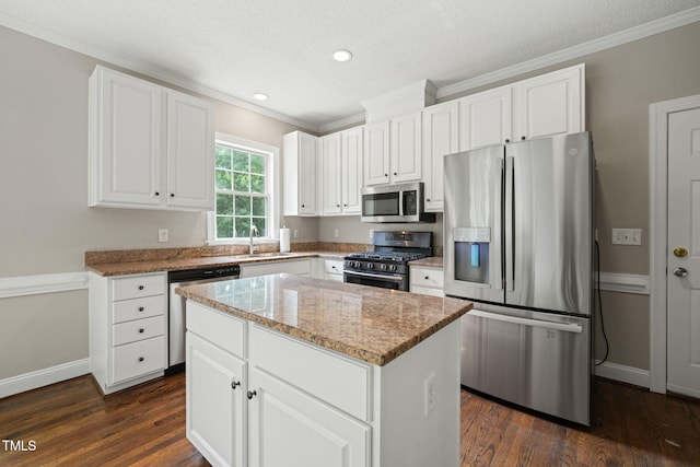 1005 Barmkin Pl, Knightdale, NC 27545 - kitchen with stainless steel appliances, ornamental molding, dark wood-style floors, a kitchen island, and light stone countertops