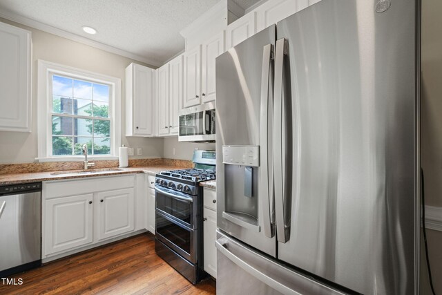 1005 Barmkin Pl, Knightdale, NC 27545 - kitchen with stainless steel appliances, a sink, white cabinets, light stone counters, and dark wood-style flooring