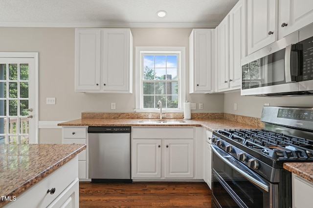 1005 Barmkin Pl, Knightdale, NC 27545 - kitchen featuring stainless steel appliances, a sink, white cabinetry, dark wood-style flooring, and ornamental molding