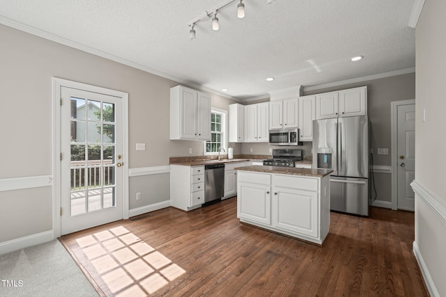 1005 Barmkin Pl, Knightdale, NC 27545 - kitchen featuring appliances with stainless steel finishes, ornamental molding, a sink, white cabinets, and dark wood-style floors