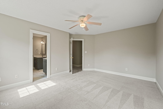 1005 Barmkin Pl, Knightdale, NC 27545 - unfurnished bedroom featuring light carpet, ensuite bathroom, baseboards, a sink, and a ceiling fan