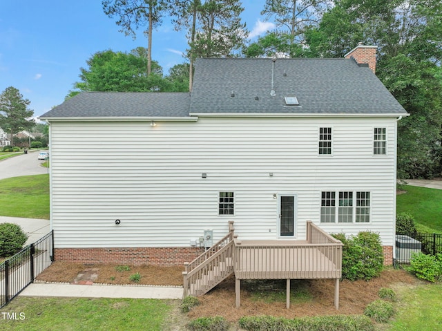 1005 Barmkin Pl, Knightdale, NC 27545 - back of house featuring fence, a wooden deck, a chimney, and roof with shingles