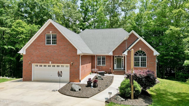 3750 Mebane Rogers Rd, Mebane, NC 27302 - view of front of home with brick siding, driveway, an attached garage, view of wooded area, and a front yard