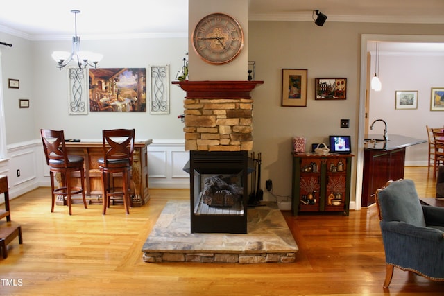 3750 Mebane Rogers Rd, Mebane, NC 27302 - dining space with light wood-style floors, a chandelier, crown molding, a wainscoted wall, and a decorative wall