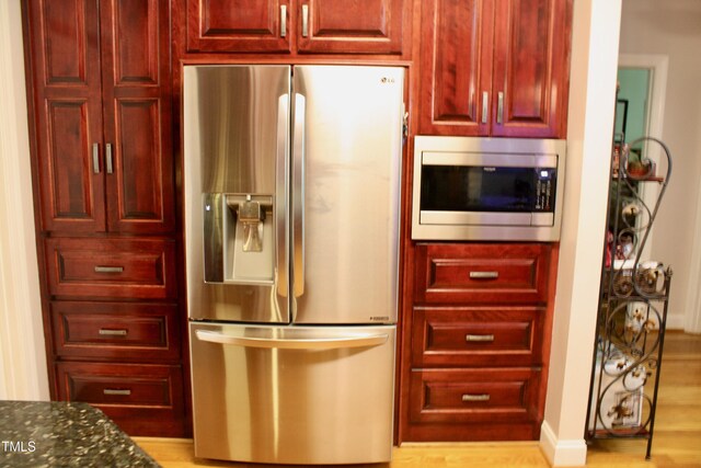 3750 Mebane Rogers Rd, Mebane, NC 27302 - kitchen with stainless steel appliances, dark brown cabinets, dark stone countertops, and light wood-style floors