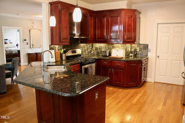 3750 Mebane Rogers Rd, Mebane, NC 27302 - kitchen featuring gas range, reddish brown cabinets, a sink, wall chimney range hood, and light wood-style floors