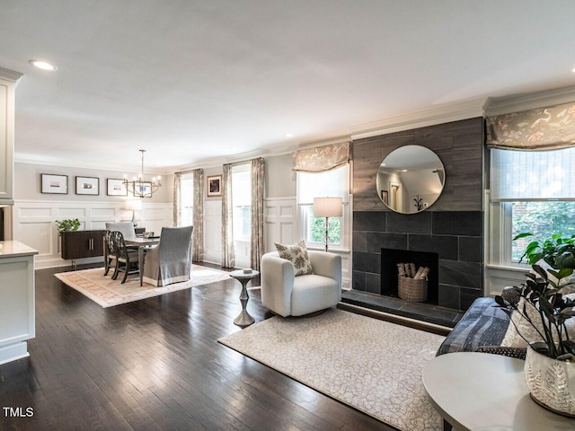 2303 Byrd St, Raleigh, NC 27608 - living area with crown molding, a chandelier, a decorative wall, a tile fireplace, and plenty of natural light
