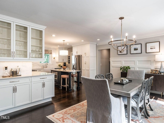 2303 Byrd St, Raleigh, NC 27608 - dining space featuring a chandelier, crown molding, dark wood-style floors, recessed lighting, and a decorative wall