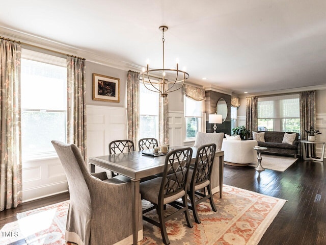 2303 Byrd St, Raleigh, NC 27608 - dining space with a decorative wall, a chandelier, ornamental molding, wood finished floors, and a wainscoted wall