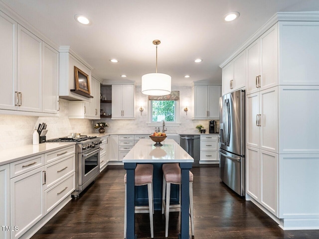 2303 Byrd St, Raleigh, NC 27608 - kitchen featuring stainless steel appliances, light countertops, a kitchen bar, a kitchen island, and recessed lighting