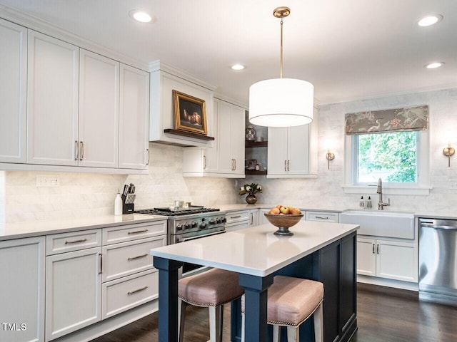 2303 Byrd St, Raleigh, NC 27608 - kitchen with a sink, appliances with stainless steel finishes, a kitchen bar, light countertops, and decorative backsplash
