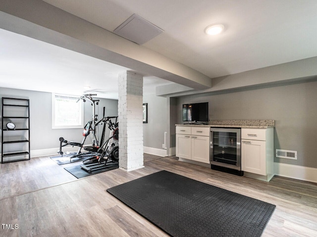 2303 Byrd St, Raleigh, NC 27608 - exercise area featuring beverage cooler, ornate columns, baseboards, and wood finished floors