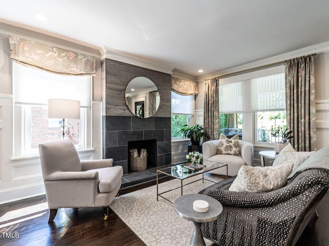 2303 Byrd St, Raleigh, NC 27608 - living area featuring wood finished floors, ornamental molding, a decorative wall, and a tile fireplace