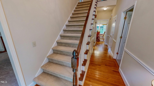 staircase featuring wood finished floors and baseboards